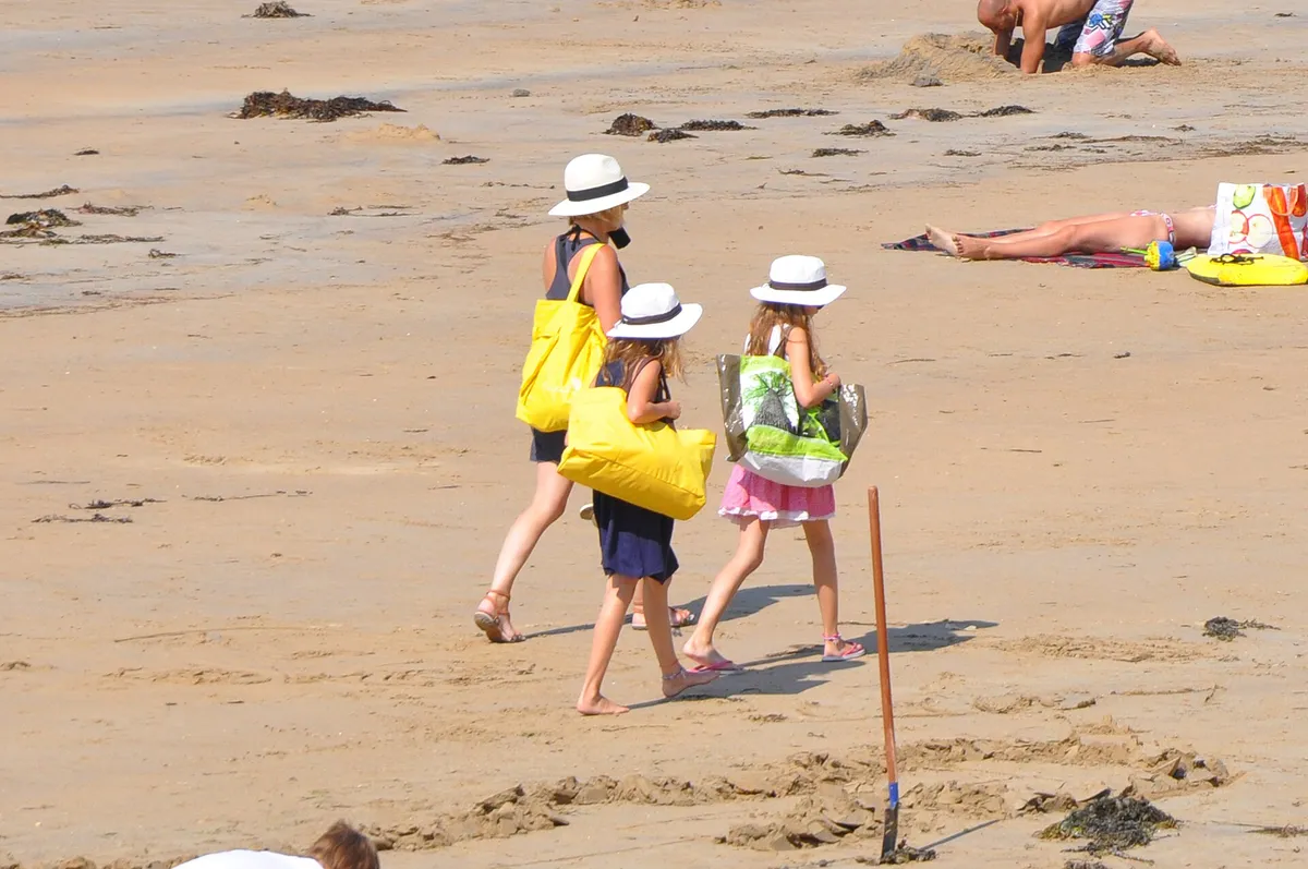 Straw sun hats lined up on a beach promenade